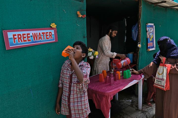 A volunteer distributes drinking water next to a bus stand on a hot summer day in Hyderabad, India, on March 21, 2024. Another month, another heat record for the planet. 