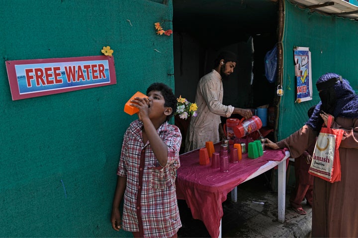 A volunteer distributes drinking water next to a bus stand on a hot summer day in Hyderabad, India, on March 21, 2024. Another month, another heat record for the planet.