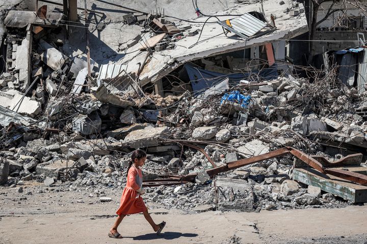 A girl walks past the rubble of a collapsed building in Rafah in the southern Gaza Strip.