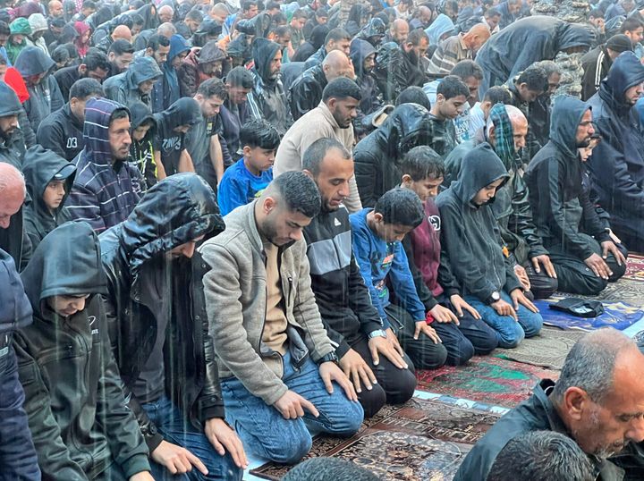 Palestinians in the Jabaliya refugee camp perform Eid al-Fitr prayer outside in the rain as Israeli attacks continue in Gaza on April 10, 2024.