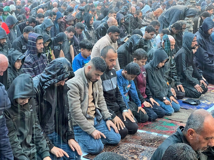 Palestinians in the Jabaliya refugee camp perform Eid al-Fitr prayer outside in the rain as Israeli attacks continue in Gaza on April 10, 2024.