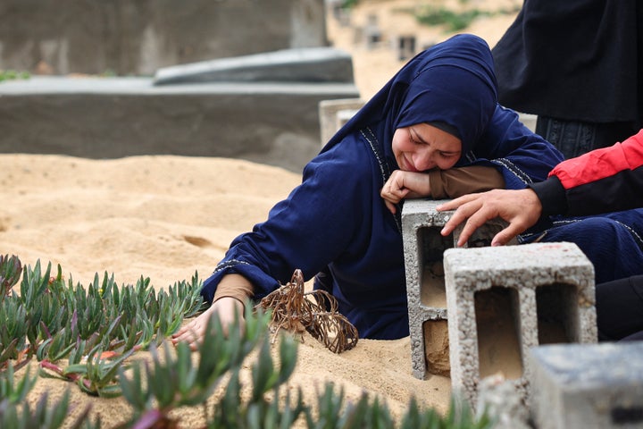 A woman cries over a loved one's grave during Eid al-Fitr, marking the end of the Muslim holy month of Ramadan, at a cemetery in Rafah in the southern Gaza Strip, on April 10, 2024.