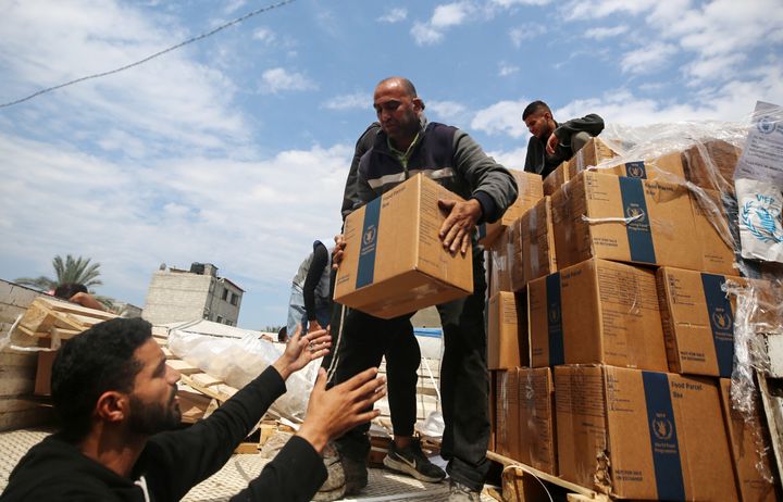 A Palestinian man carries boxes of aid distributed before Eid al-Fitr, which marks the end of Ramadan, amid the ongoing conflict between Israel and Hamas, in Deir al-Balah, Gaza, on April 8, 2024.