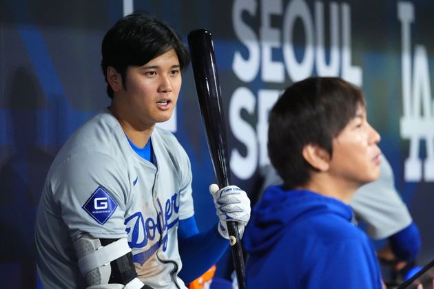 韓国ソウルで開かれたドジャース開幕戦。ベンチで話す大谷翔平選手と水原一平氏（2024年3月20日）