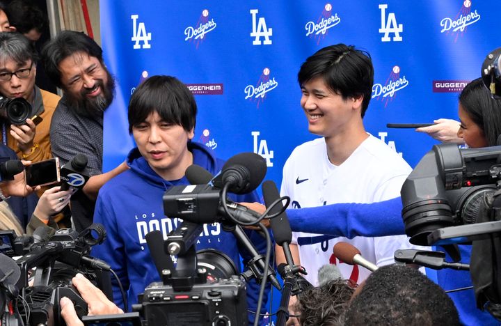 Shohei Ohtani, right, of the Los Angeles Dodgers speaks to the media with the help of his interpreter Ippei Mizuhara in early February. 