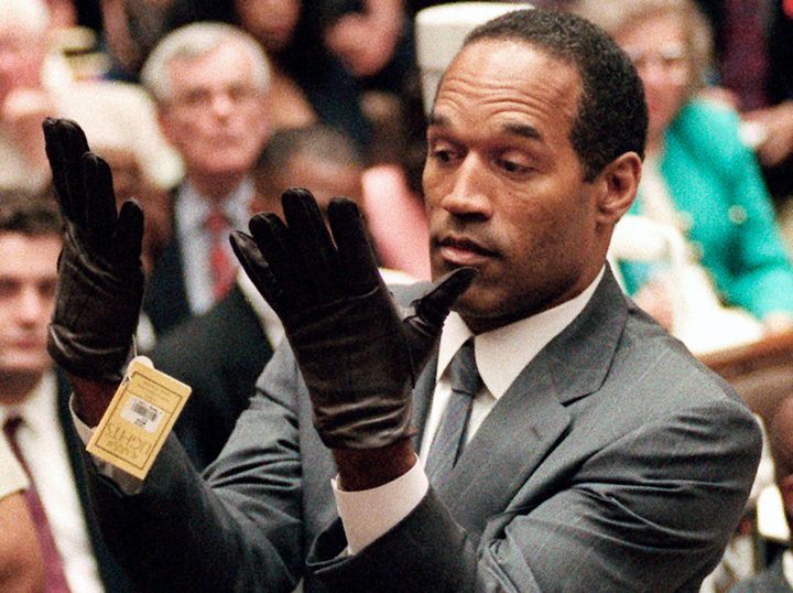FILE - In this June 21, 1995 file photo, O.J. Simpson holds up his hands before the jury after putting on a new pair of gloves similar to the infamous bloody gloves during his double-murder trial in Los Angeles. Simpson, the decorated football superstar and Hollywood actor who was acquitted of charges he killed his former wife and her friend but later found liable in a separate civil trial, has died. He was 76. (Vince Bucci/Pool Photo via AP, File)