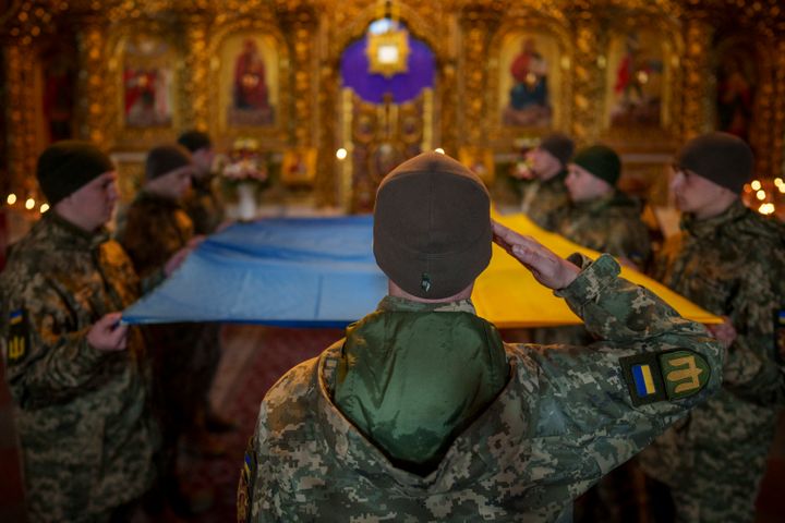 Ουκρανοί στρατιώτες κρατούν την εθνική σημαία πριν την τοποθετήσουν στο φέρετρο ενός πεσόντος στρατιώτη στο μοναστήρι του Αγίου Μιχαήλ με τον χρυσό τρούλο στο Κίεβο, Ουκρανία, Τρίτη 26 Μαρτίου 2024.