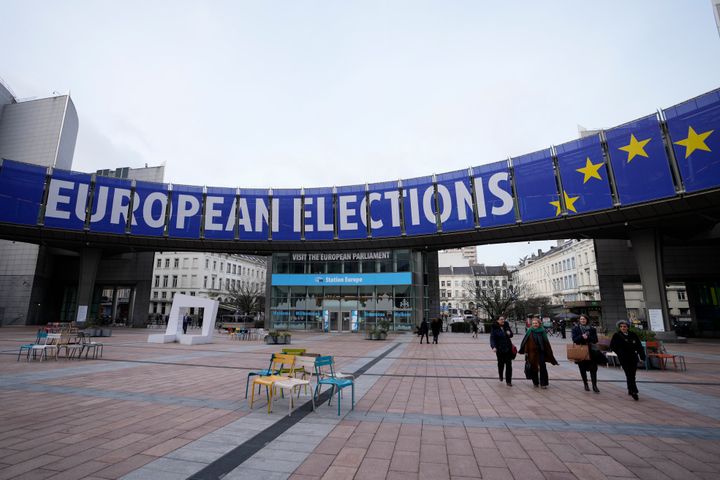 Άνθρωποι περπατούν κάτω από ένα πανό που διαφημίζει τις ευρωεκλογές έξω από το Ευρωπαϊκό Κοινοβούλιο στις Βρυξέλλες, στις 24 Ιανουαρίου 2024.