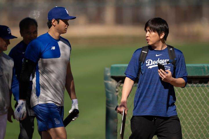 FILE - Los Angeles Dodgers' Shohei Ohtani walks with interpreter Ippei Mizuhara at batting practice during spring training baseball workouts in Phoenix on Feb. 12, 2024. (AP Photo/Carolyn Kaster, File)