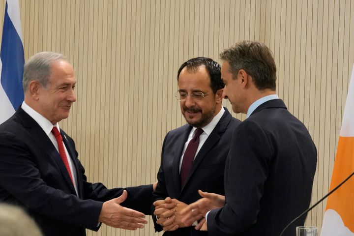 Cypriot President Nikos Christodoulides, center, Greek Prime Minister Kyriakos Mitsotakis, right, and Israeli Prime Minister Benjamin Netanyahu shake hands after a press conference at the presidential palace in Nicosia, Cyprus, on Monday, Sept. 4, 2023. Israel's prime minister is floating the idea of building infrastructure projects such as a fiber optic cable linking countries in Asia and the Arabian Peninsula with Europe through Israel and Cyprus. (AP Photo/Petros Karadjias, Pool)