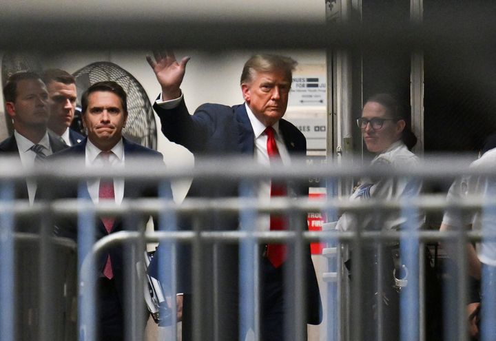 Former US President Donald Trump waves as he returns to the courtroom after a break during the first day of his trial for allegedly covering up hush money payments linked to extramarital affairs, at Manhattan Criminal Court in New York City on April 15, 2024. (Photo by ANGELA WEISS / POOL / AFP) (Photo by ANGELA WEISS/POOL/AFP via Getty Images)