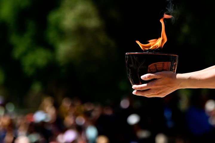 ATHENS, GREECE - APRIL 15: Actress playing the role of the High Priestess, holds a cauldron with a Olympic flame during the flame lighting ceremony for the Paris 2024 Summer Olympics at the Ancient Olympia archeological site, birthplace of the ancient Olympics in southern Greece on April 15, 2024 in Olympia, Greece. (Photo by Milos Bicanski/Getty Images)