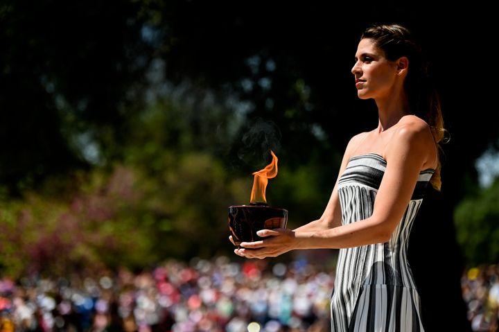 ATHENS, GREECE - APRIL 15: Actress playing the role of the High Priestess, holds a cauldron with the Olympic flame during the flame lighting ceremony for the Paris 2024 Summer Olympics at the Ancient Olympia archeological site, birthplace of the ancient Olympics in southern Greece on April 15, 2024 in Olympia, Greece. (Photo by Milos Bicanski/Getty Images)