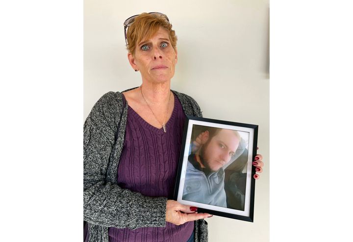 Heather DeWolf holds up a photo of her late son, Zach DeWolf, who died in 2020 at age 33. DeWolf fears the ashes she received from the Colorado funeral home are not her son's.