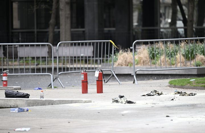 Fire extinguishers are seen after a man set himself ablaze in a park across from the Manhattan Criminal Court in New York City on Friday.