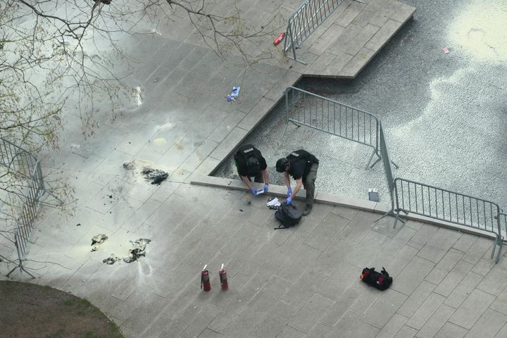 New York police officers inspect a backpack left at the scene of Friday's incident.