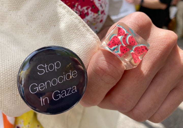 シゲさんが着用したスイカ柄の指輪と、かばんにつけた「Stop Genocide In Gaza（ガザでのジェノサイドを止めろ）」と書かれた缶バッチ