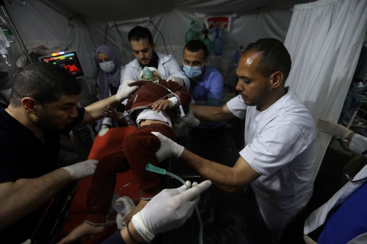Palestinian medics carry a child wounded in the Israeli bombardment of the Gaza Strip, to the Kuwaiti Hospital in Rafah refugee camp, southern Gaza Strip, early Saturday, April 20, 2024. (AP Photo/Ismael Abu Dayyah)