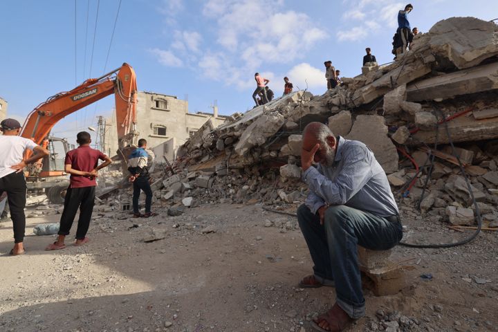 A Palestinian man waits for news of his daughter as rescue workers search for survivors under the rubble of a building hit in an overnight Israeli bombing in Rafah, Gaza, on April 21, 2024.