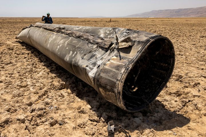 A week after Iran's retaliatory missile barrage on Israel, a photographer approaches the remains of a missile that landed on the shore of the Dead Sea, on April 21, 2024.