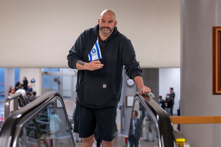 Fetterman holds a small Israel flag as he heads to the Senate chamber for a vote at the Capitol in Washington. He has established himself as perhaps Israel’s most loyal and outspoken Democratic ally.