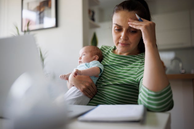 Tired and worried mother working at home
