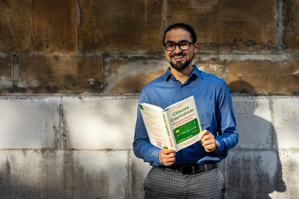 Bloomberg reporter Akshat Rathi poses with his debut book "Climate Capitalism."