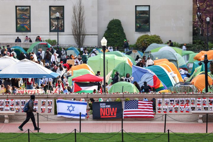 A man walks past Israeli and U.S. flags alongside portraits of Israelis taken hostage by Hamas in front of the pro-Palestinian encampment at Columbia University in New York on Tuesday. President Joe Biden has condemned any antisemitism on college campuses as protesters at Columbia University spent their fifth day demanding the school sever financial ties with companies that aid in the war.