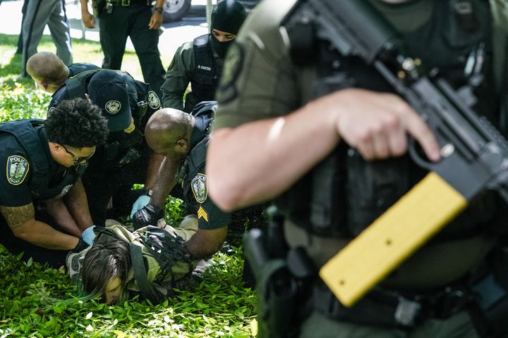 Police officers restrain a demonstrator during a pro-Palestinian protest against the war in Gaza at Emory University on April 25, 2024, in Atlanta, Georgia.