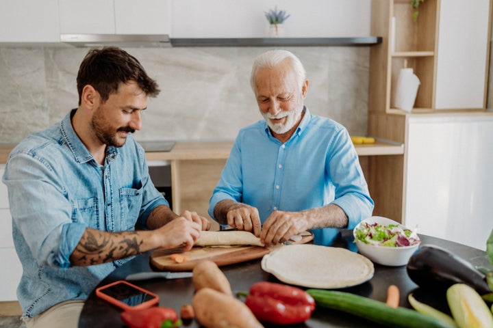 Son helping his father make burrito