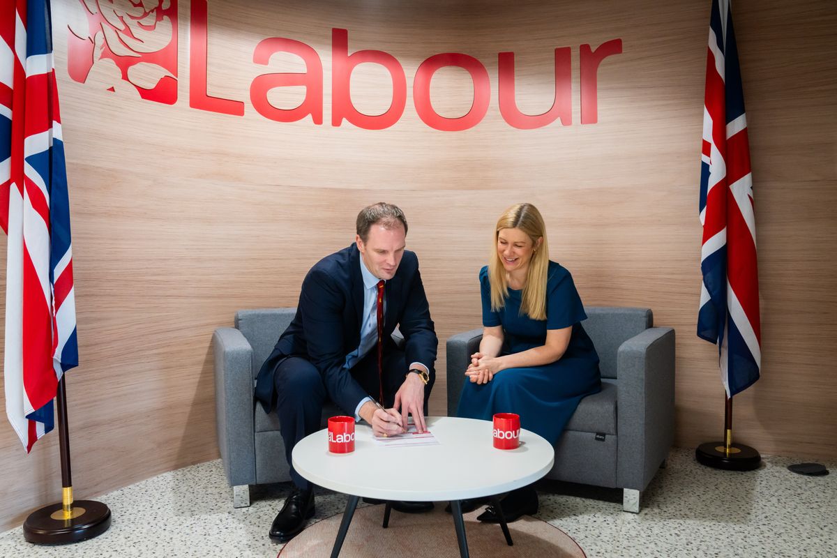 Dr Dan Poulter signs his Labour membership forms as Ellie Reeves looks on.
