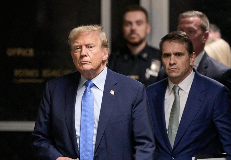 Former President Donald Trump walks out of Manhattan Criminal Court to speak to the press at the end of Friday's trial proceedings in the hush money case. 