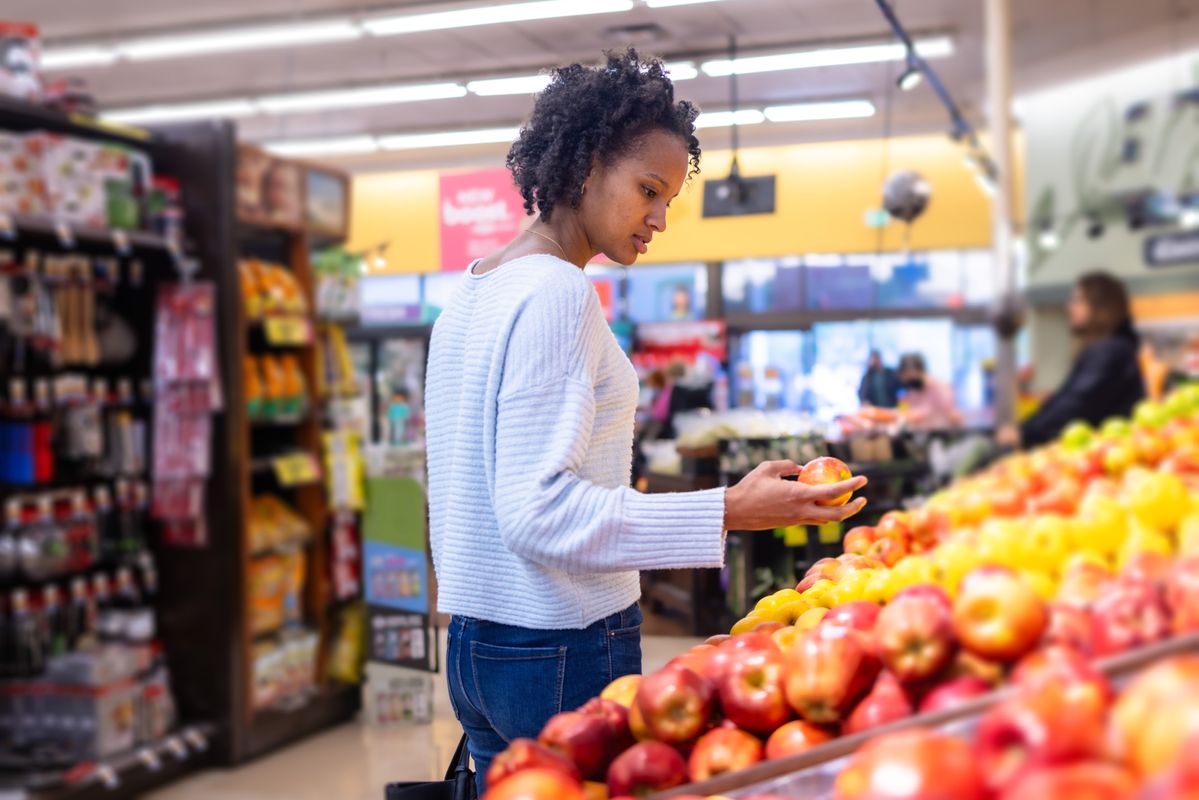 Young black woman browsing produce in grocery store