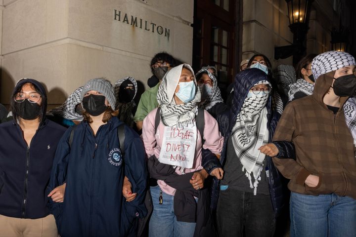 Demonstrators on Tuesday lock arms to stop authorities from reaching fellow protesters who barricaded themselves inside Hamilton Hall. The scene was reminiscent of protests that occurred on Columbia University's campus 56 years earlier.