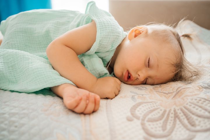 child sleeps soundly on the bed in a hotel room on vacation while traveling