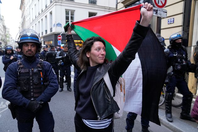 Μια γυναίκα κρατάει μια σημαία της Παλαιστίνης κοντά στο πανεπιστήμιο Sciences-Po στο Παρίσι την Παρασκευή 26 Απριλίου 2024.