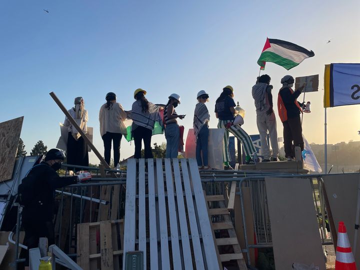 UCLA students erect barricades and fly the flag of Palestine on the campus.