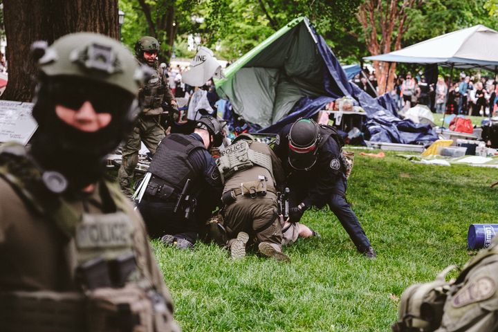 Heavily armed policemen arrest a protester on the grounds of the University of Virginia after police declared an unlawful gathering on May 4, 2024 in Charlottesville, Virginia.
