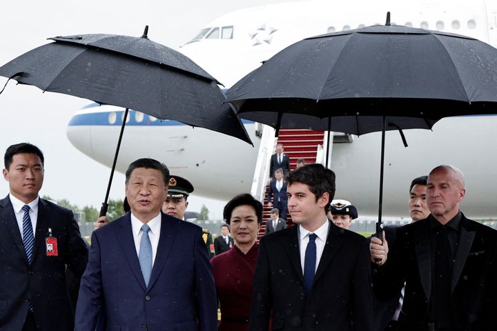 China's President Xi Jinping and his wife, Peng Liyuan, walk under umbrellas with Franch Prime Minister Gabriel Attal upon their arrival for an official two-day state visit. (Photo by STEPHANE DE SAKUTIN/POOL/AFP via Getty Images)