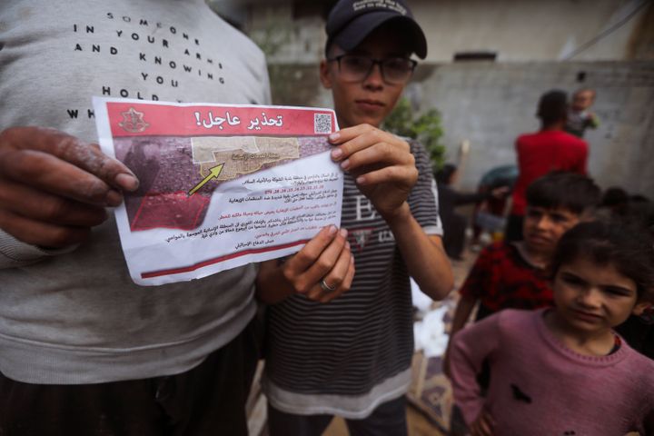 Palestinians hold leaflets dropped by Israeli planes calling on them to evacuate ahead of an Israeli military operation in Rafah, southern Gaza Strip, Monday, May 6, 2024. The order affects tens of thousands of people and could signal a broader invasion of Rafah, which Israel has identified as Hamas' last major stronghold after seven months of war. (AP Photo/Ismael Abu Dayyah)