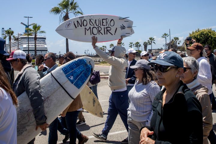 A demonstrator holding a bodyboard written in Spanish "I don't want to die" protests the disappearance of foreign surfers in Ensenada, Mexico, on May 5, 2024. 