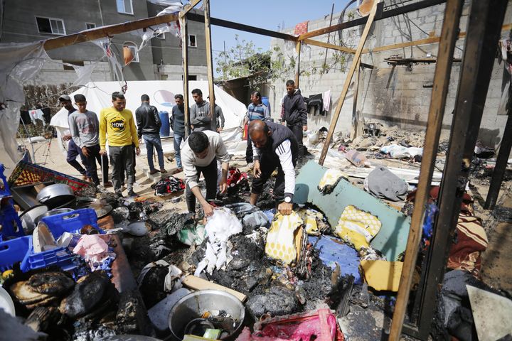 3 月 26 日，以色列空袭加沙汗尤尼斯的马瓦西区后，人们正在清理被毁的帐篷。