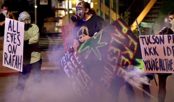 Demonstrators retreat along University Boulevard in a cloud of teargas as law enforcement officers use chemical ammunition to clear an encampment off the University of Arizona campus, Friday, May 10, 2024, Tucson, Az. (Kelly Presnell/Arizona Daily Star via AP)