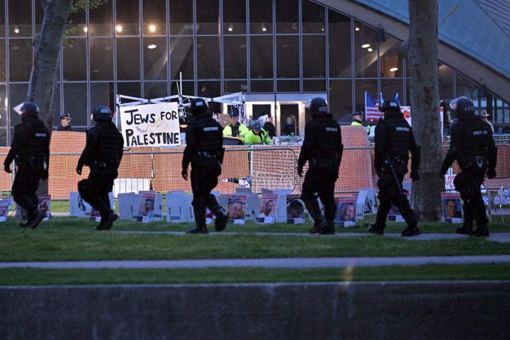 A line of police in riot gear walk past police dismantling pro-Palestinian encampment at MIT, before dawn Friday, May 10, 2024, in Cambridge, Mass. (AP Photo/Josh Reynolds)