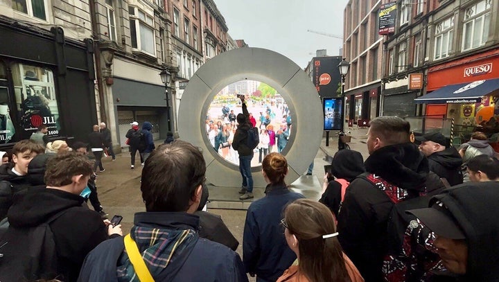 People watch a live stream portal between Dublin and New York on Monday. The Irish portal was temporarily closed following "inappropriate behavior."