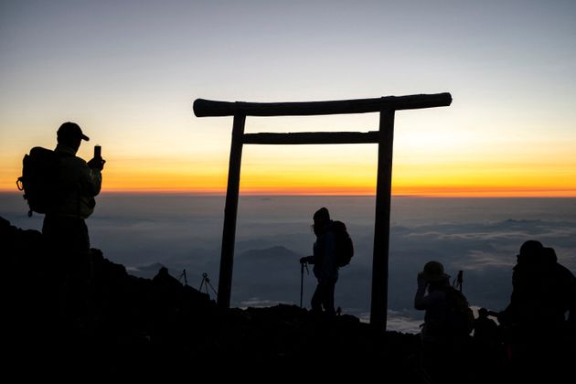 富士山の山頂で「ご来光」を迎えた登山者＝2021年7月19日