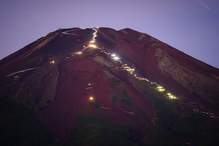 山頂を目指す登山者のライトが、富士山の登山道を照らし出す