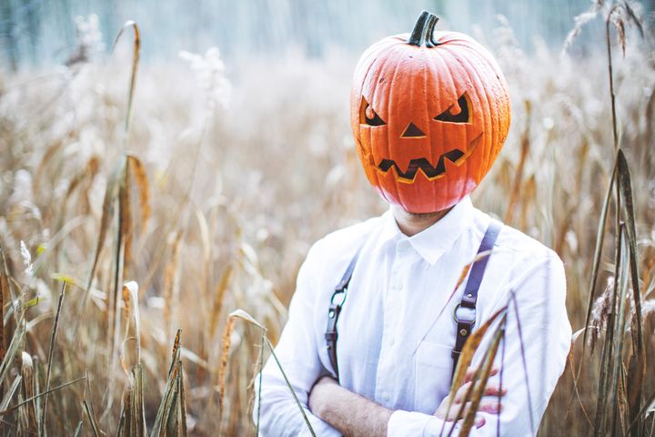 Man celebrate halloween with pumpkin on his head