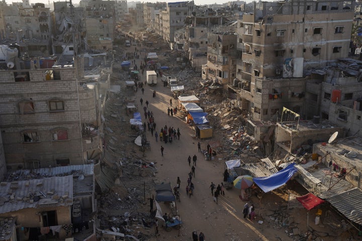 Palestinians walk through the debris after an Israeli air and ground offensive in Khan Younis, southern Gaza Strip, Wednesday, May 15, 2024. 