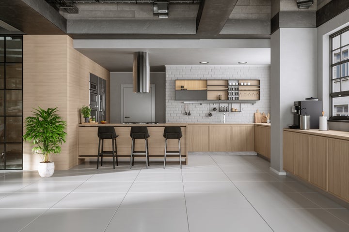 Modern Kitchen Interior With Wooden Cabinets, Kitchen Island, Chairs And Potted Plant